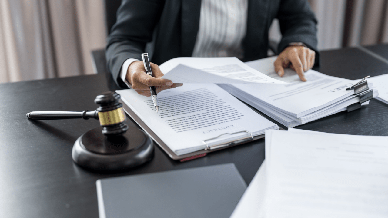 Traffic ticket lawyer reviewing a citation and legal book at a desk