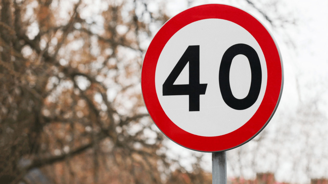 Speed limit sign displaying 40 mph on a roadside with trees in the background