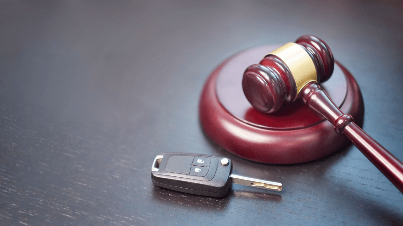 Gavel and car key on dark desk symbolizing traffic court cases