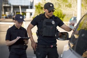 Police officers inspect a driver’s license during a traffic stop.