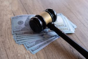 What is the charge of suspended license – gavel on money symbolizing legal penalties and fines
