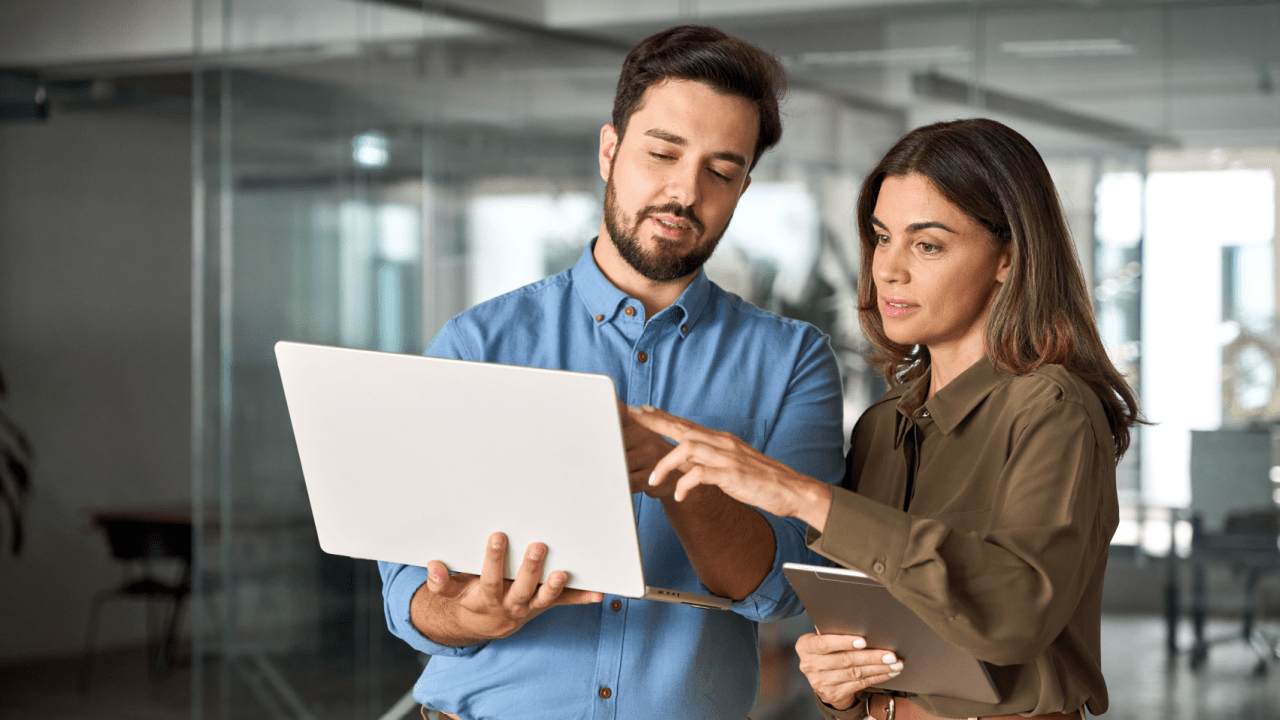 Two legal professionals discussing common traffic violations and defenses on laptop in modern office setting
