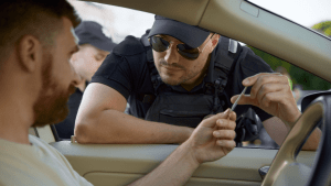 Police officer conducting traffic stop discussing how long does a reckless driving stay on your record in NC with driver