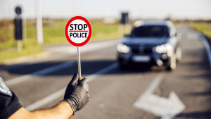 Police officer holding stop sign during traffic enforcement illustrating what is the law for reckless driving in NC