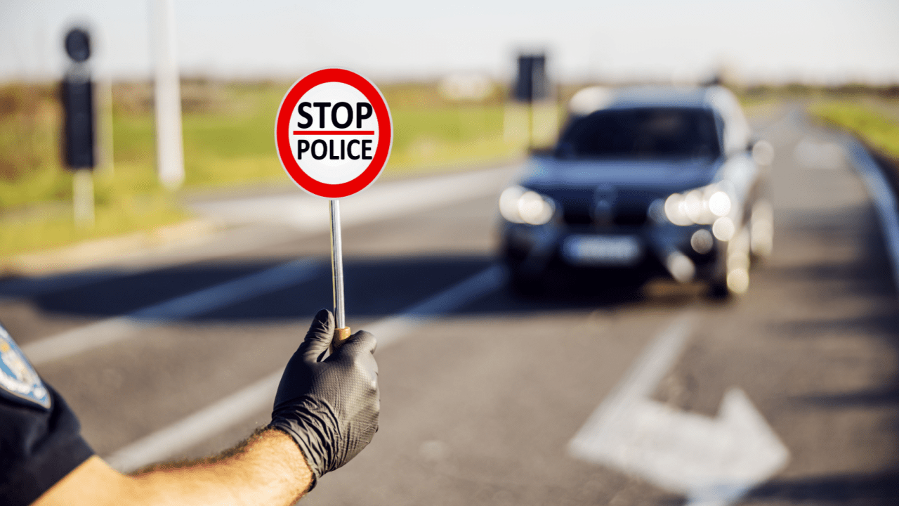 Police officer holding stop sign during traffic enforcement illustrating what is the law for reckless driving in NC