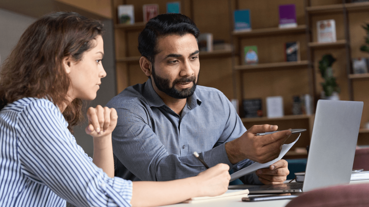 Couple consulting with lawyer on how to beat a speeding ticket, reviewing legal documents at office desk