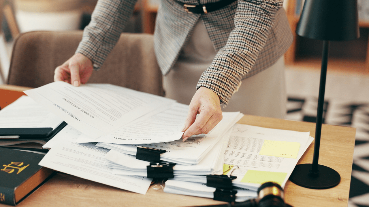 Person reviewing legal documents while choosing the right traffic lawyer for their case