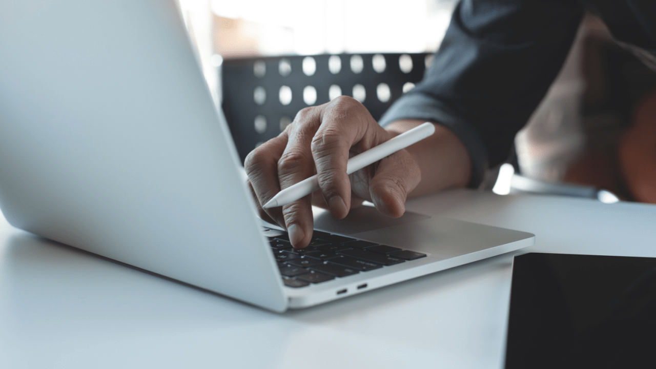 Person using laptop and smartphone to research affordable traffic ticket lawyer options online, comparing legal services and pricing