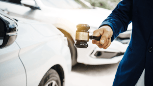 Professional holding gavel next to car representing how can a lawyer prevent license suspension cases