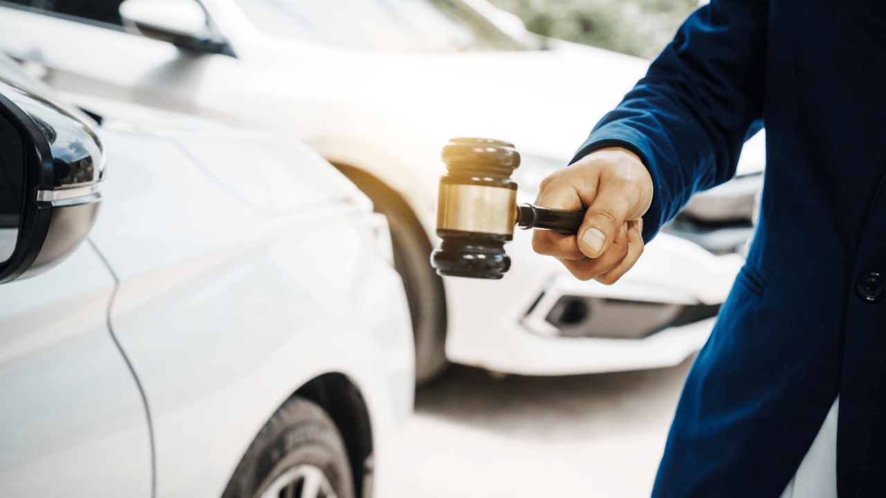 Professional holding gavel next to car representing how can a lawyer prevent license suspension cases