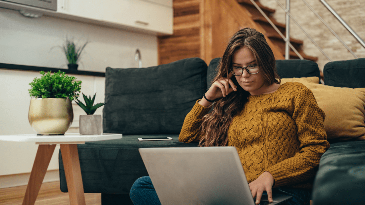 Woman with glasses researching on laptop at home, wondering do I need a lawyer for a traffic ticket while reviewing legal information online