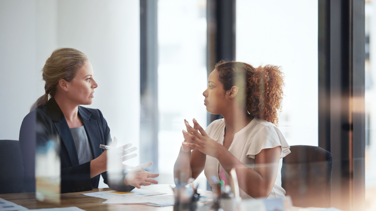 Professional female attorney consulting with client in modern office, discussing how much does a traffic violation lawyer cost and legal service pricing options
