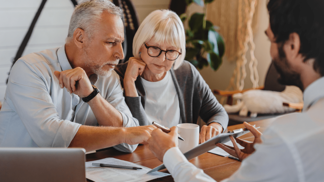 Mature couple consulting with lawyer about costs and fees of traffic lawyers during consultation meeting