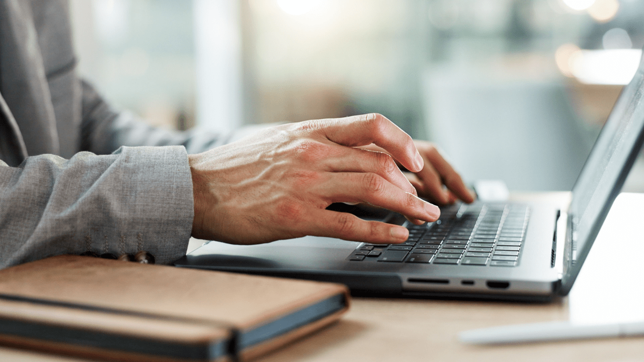 Professional hands typing on laptop computer researching legal options, investigating can a traffic lawyer reduce my ticket and exploring defense strategies