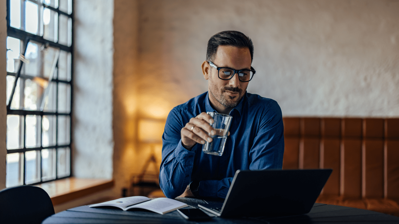 Professional man with glasses working on laptop in modern office setting, representing a traffic lawyer providing expert legal services and case consultation