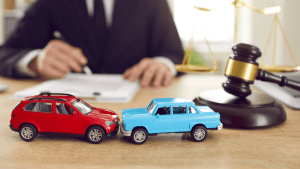Traffic violation lawyer consultation with toy cars and gavel representing legal defense services