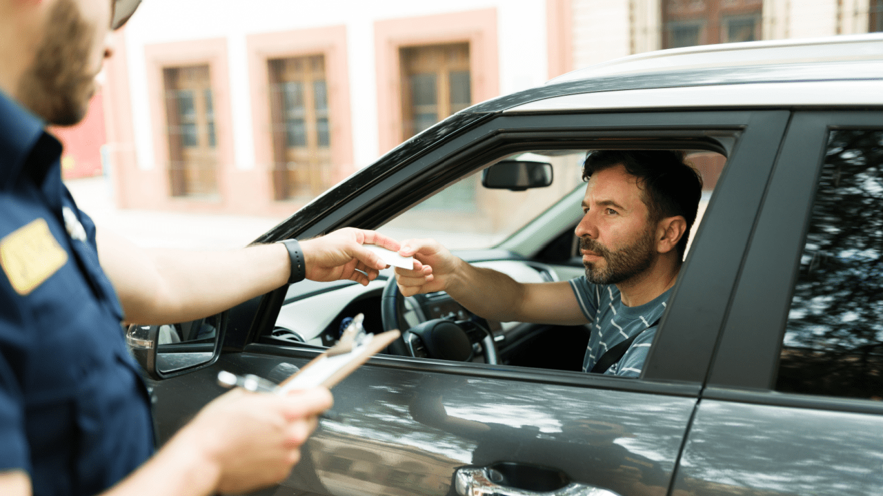 Police officer giving speeding ticket to driver wondering will a speeding ticket increase my insurance rate