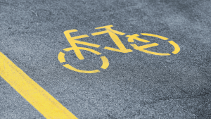 Yellow bicycle lane symbol painted on road showing what are the traffic laws for bicycles apply