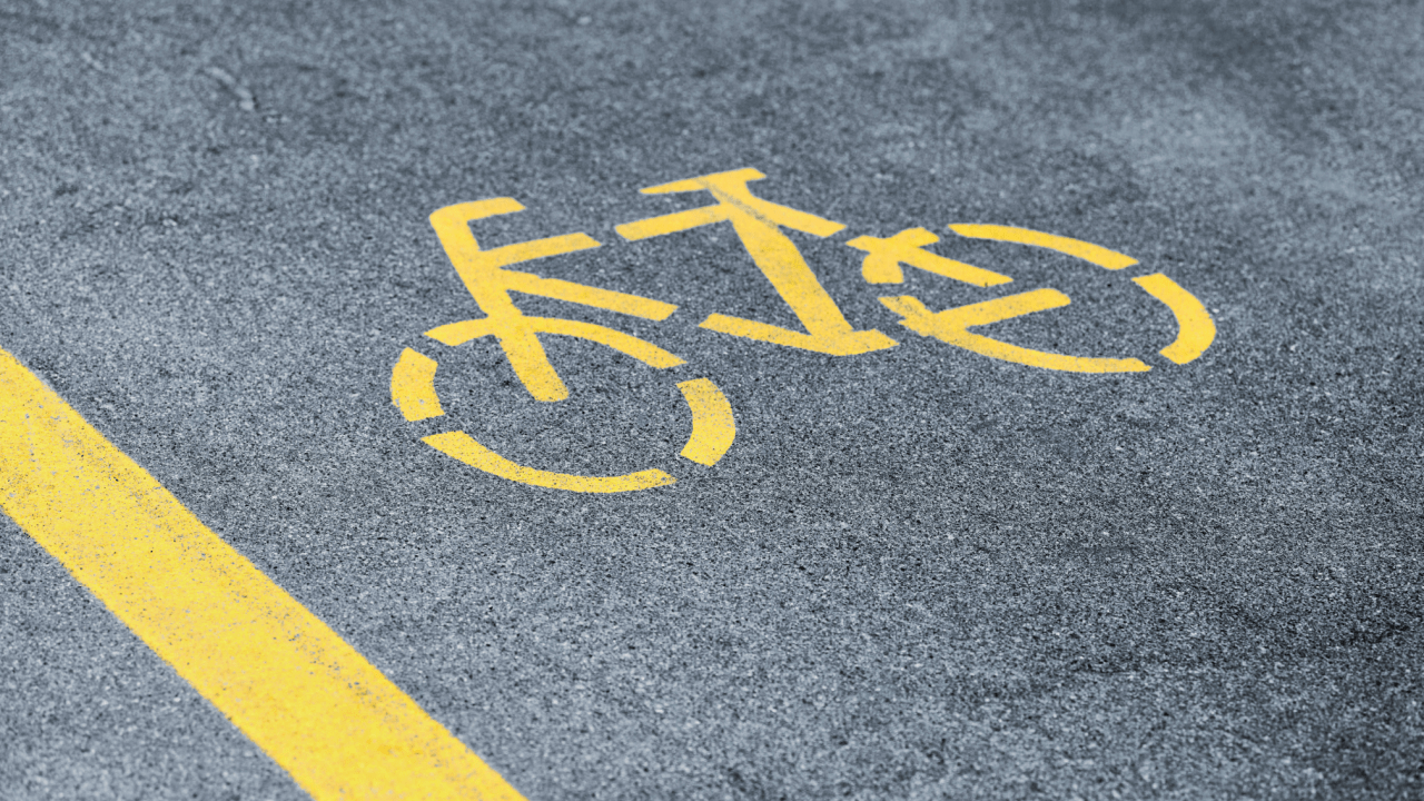 Yellow bicycle lane symbol painted on road showing what are the traffic laws for bicycles apply