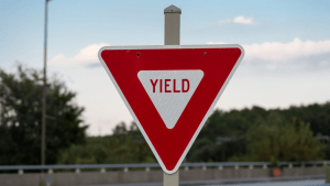 Red and white triangular yield sign showing what does yield mean in terms of traffic laws