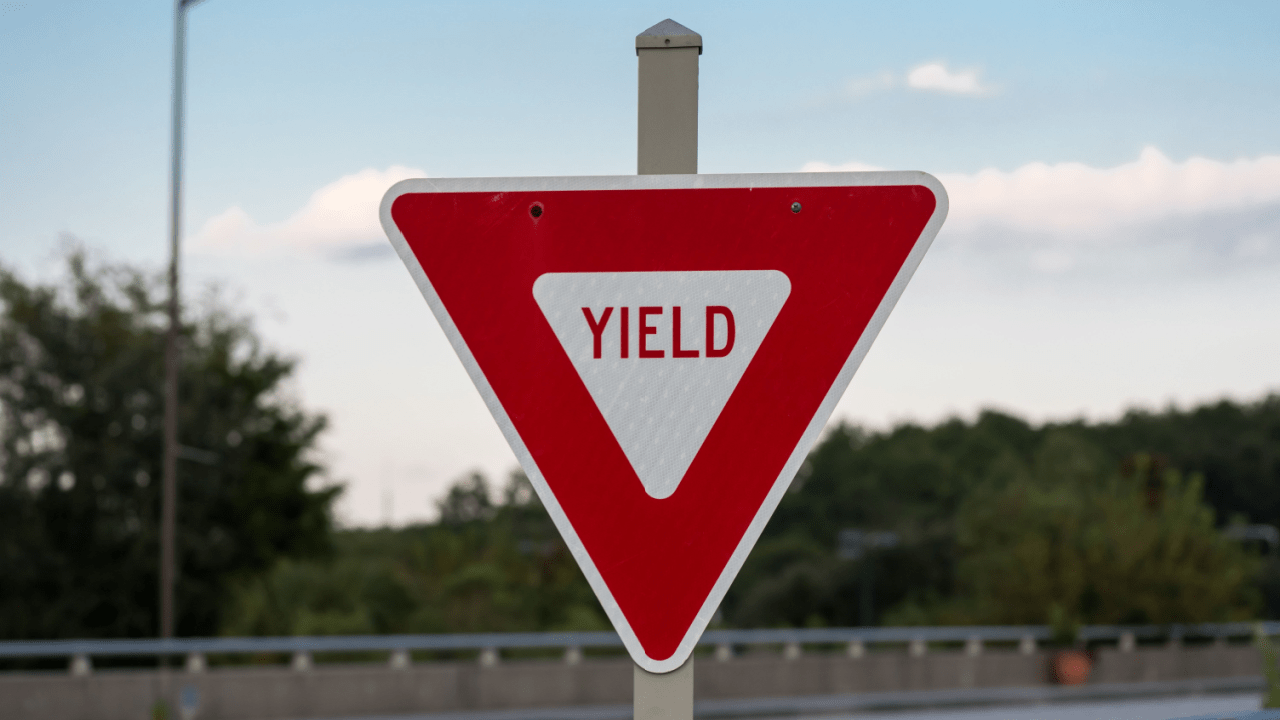 Red and white triangular yield sign showing what does yield mean in terms of traffic laws