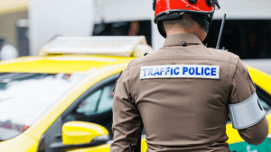 Traffic police officer enforcing traffic laws at scene with yellow vehicle
