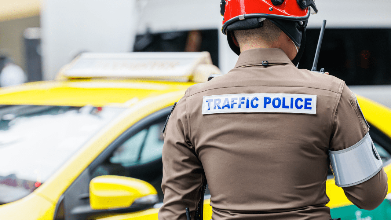 Traffic police officer enforcing traffic laws at scene with yellow vehicle