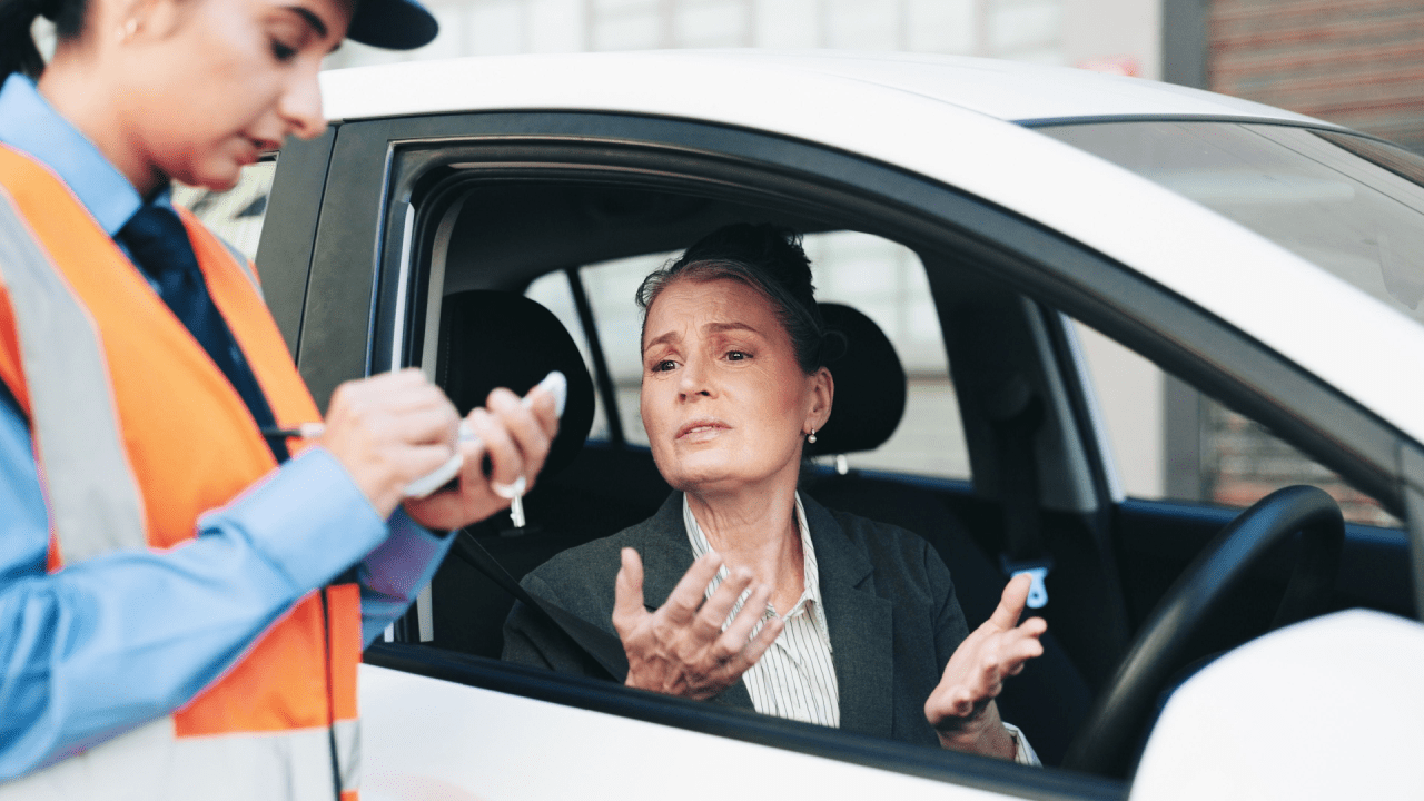 Woman receiving traffic ticket from officer - understanding when did traffic laws begin helps with modern violation defense