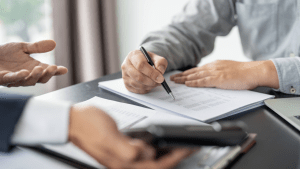 Professional legal consultation with document signing, representing someone asking do I need a traffic lawyer for a red light ticket while reviewing legal options