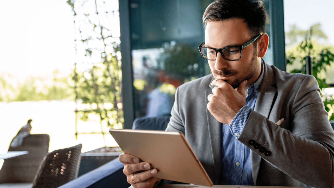 Professional man in business suit reviewing tablet, representing traffic lawyers for multiple traffic violations handling complex cases with digital case management