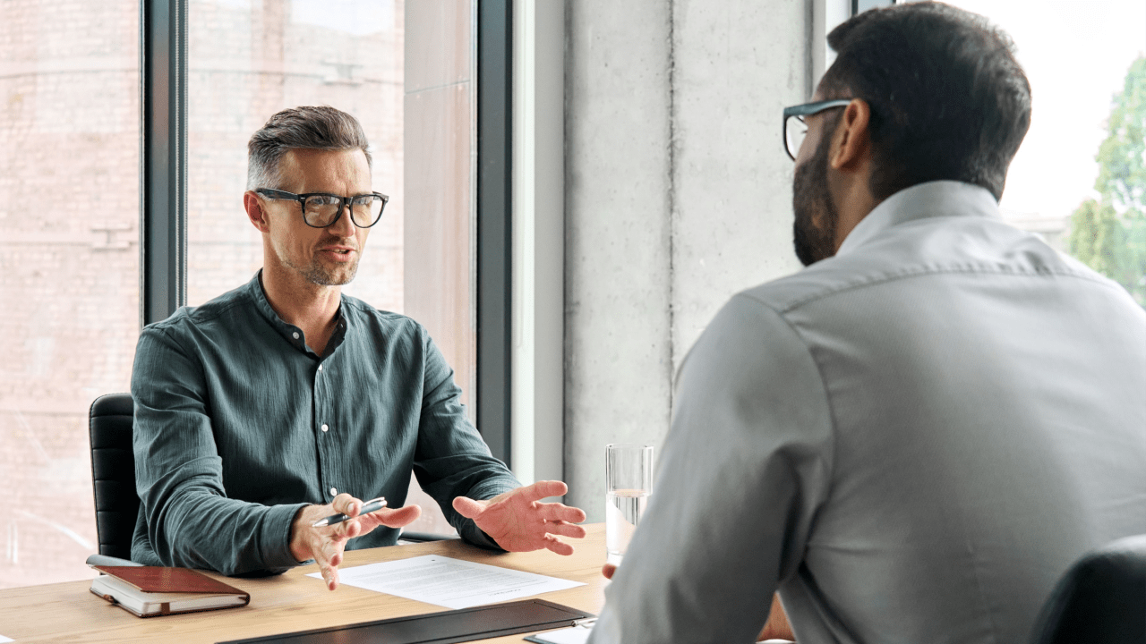 Male attorney with glasses consulting with client in modern office, explaining do traffic lawyers really help in speeding cases through expert legal guidance and case strategy