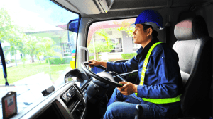 Commercial truck driver in safety vest understanding how bad DOT violations impact CDL career