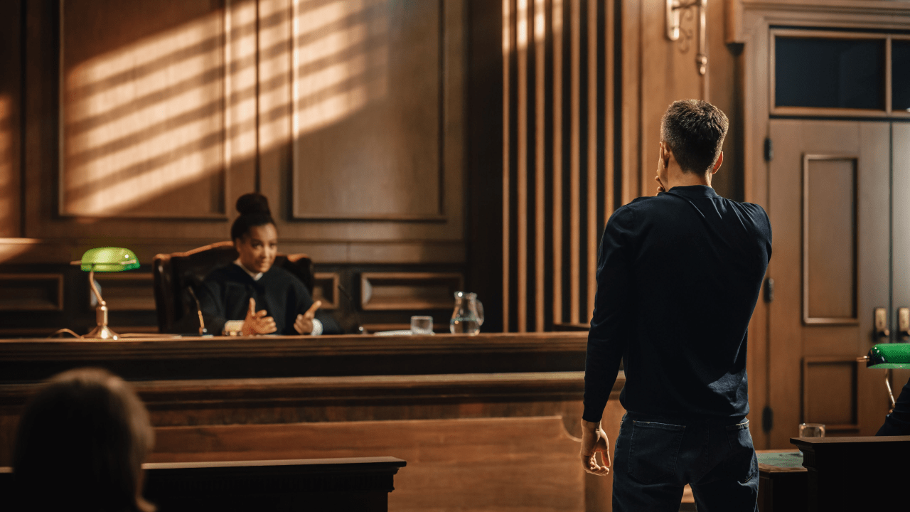 Defendant standing before judge learning what happens if your excuse fails in court during traffic violation hearing