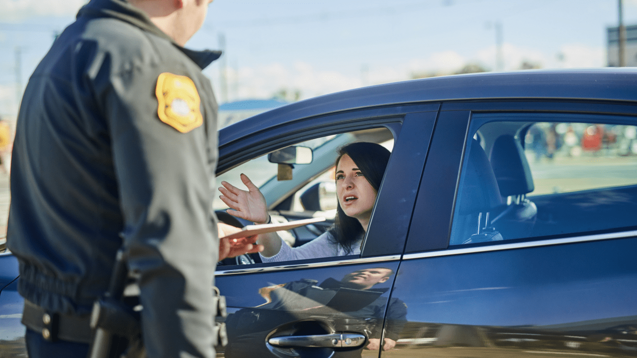 Woman explaining what to say when fighting a traffic ticket during roadside stop with police officer