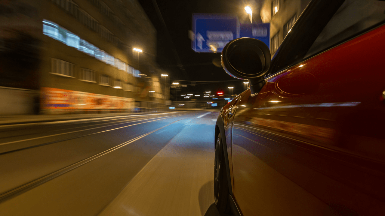 Best plea bargain for speeding ticket representation with motion blur showing car driving fast through urban tunnel