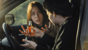Passengers in car with alcoholic beverage discussing whether you can drink as a passenger under state law