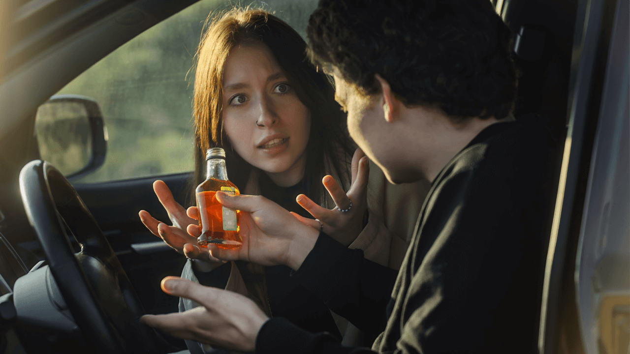 Passengers in car with alcoholic beverage discussing whether you can drink as a passenger under state law