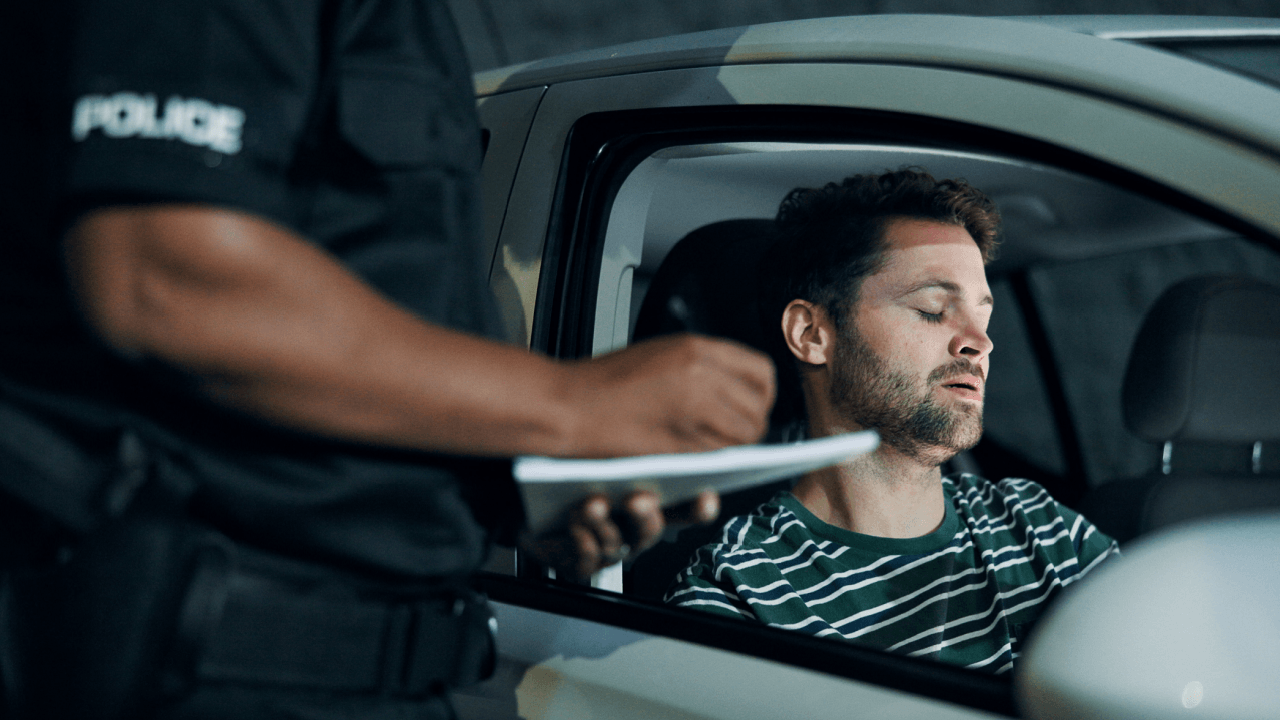 Police officer issuing a careless driving ticket to a driver pulled over in a vehicle