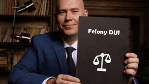 Attorney holding Felony DUI document with justice scales illustrating whether DUI is treated as a felony under some state laws
