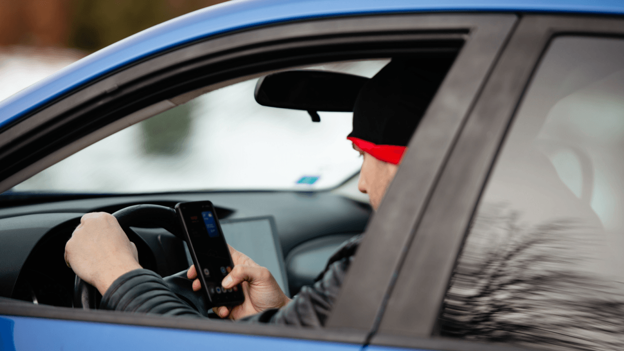 Driver using phone while driving illustrating what is careless driving behavior on the road
