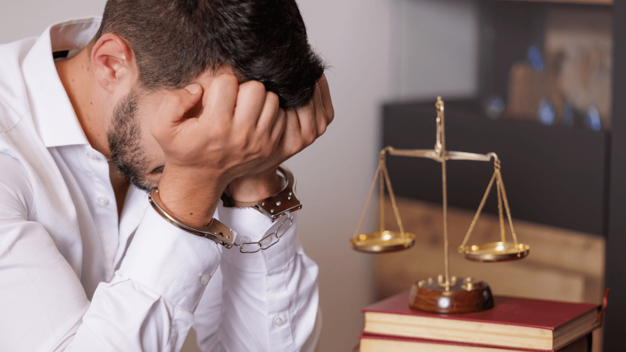 Will I go to jail for careless driving — man in handcuffs sitting before scales of justice